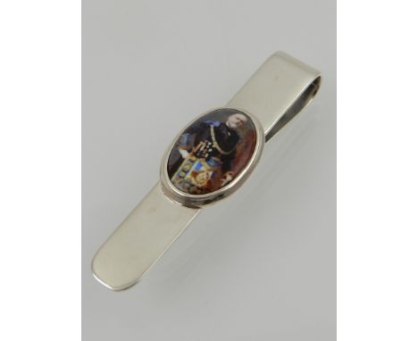 A silver money clip set with an enamel plaque. 