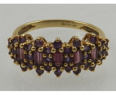 A 9 carat yellow gold, amethyst, and garnet half eternity cluster ring. 