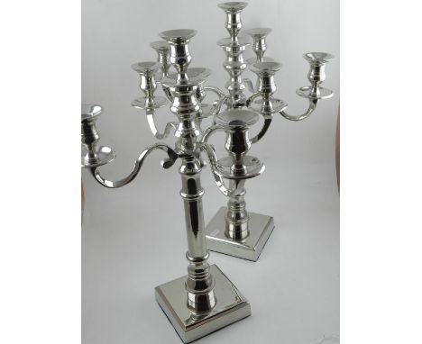 A pair of silver plated five light candelabra, raised on square bases. 