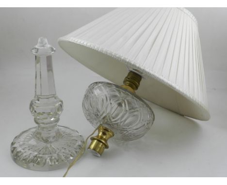 A crystal glass table lamp, having faceted stem, with reservoir and cream shade. 