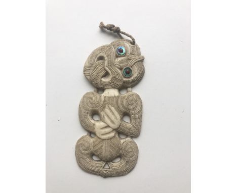 An early 19th Century New Zealand Maori "Tiki Hei," whale bone Pendant, with carved native figure and typical body art, and i
