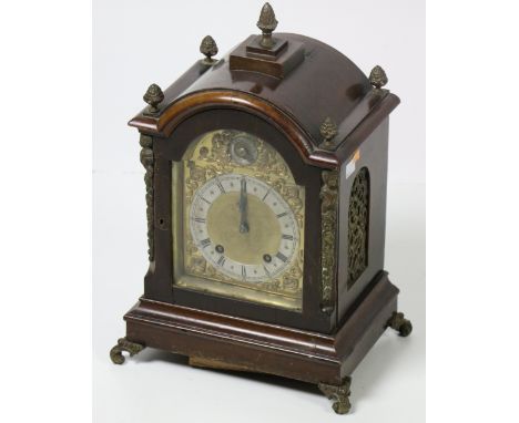 A 19th Century mahogany Bracket Clock, the arched top with acorn finials over a brass dial with Roman numerals on ormolu scro