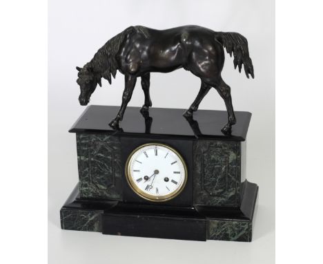 A Connemara and black marble Mantle Clock, with enamel dial and Roman numerals with a horse surmounted.(1)