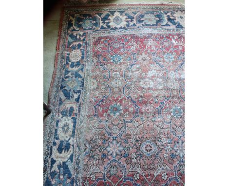 A 19th Century red ground Oriental Carpet, with floral centre and large blue ground border, 360cms x 247cms (142" x 97"). (1)