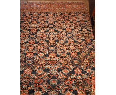 A large blue ground and floral decorated Oriental Carpet, worn and cut (with side present) 22'6" x 16' (688cms x 488cms). (1)