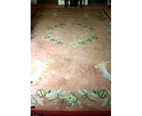 An attractive pink ground floral decorated Donegal woollen Carpet, the central garland with similar border, the corners with 