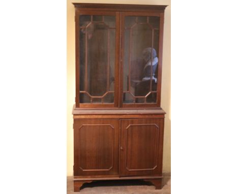 A small Georgian style wooden Bookcase, with two glazed doors, on bracket feet. (1)