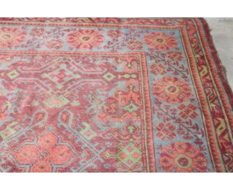 An old red ground Carpet, with wide multiple borders, deep blue ground ditto, approx. 422cms x 341cms (134" x 166"). (1)