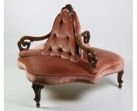 A Victorian walnut framed "Conversation" Centre Chair, with pierced scroll decorated arms on carved cabriole legs, covered in