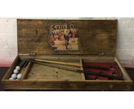 A 'Skill Ball' vintage putting game in wooden box containing two vintage golf clubs, 'British Made The Unbreakable' 