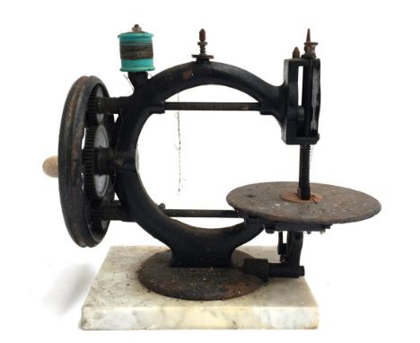 A 19th century sewing machine on marble base with ceramic handle 