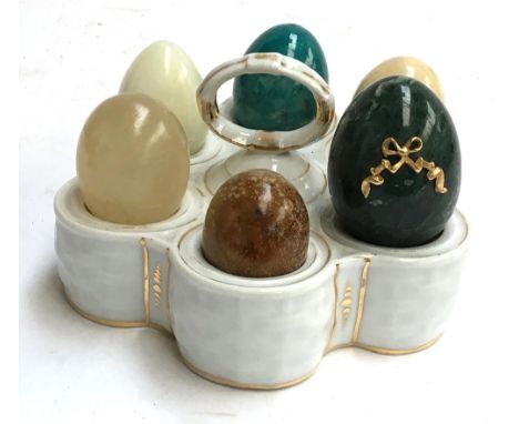 A ceramic egg holder with six polished stone eggs 