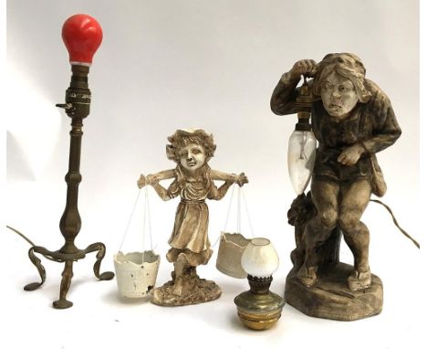 A three legged brass table lamp, very small oil lamp with glass shade; a plaster lamp in the form of an ugly man carrying a l