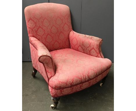 A small armchair, with outward scrolling arms on turned legs and ceramic casters 