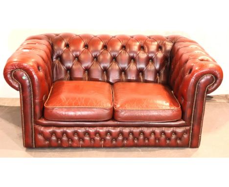 Oxblood red leather two seat Chesterfield sofa, 155 x 90 x 70H cm. Not available for in-house P&amp;P, contact Paul O'Hea at 