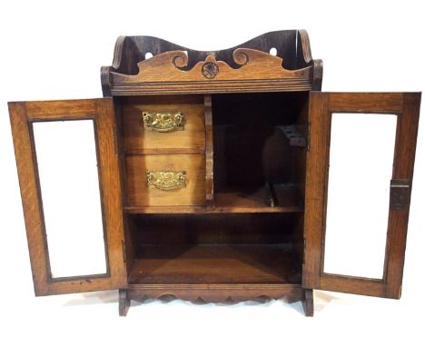 Oak fitted smokers cabinet, two glazed doors enclose a three pipe rack and two drawers, 32 x 18 x 45 cm. P&amp;P Group 3 (£25