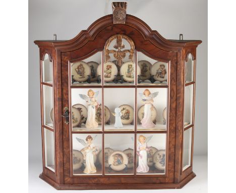 Walnut hanging display case full of 25 Goebel plates and 5 Goebel Engels.&nbsp;20th century.&nbsp;Dimensions cabinet: H 73 x 