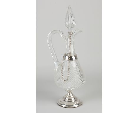 Crystal decanter with silver, 833/000.&nbsp;Jug with diamond cut placed on a round silver base with pearl rims and a silver r
