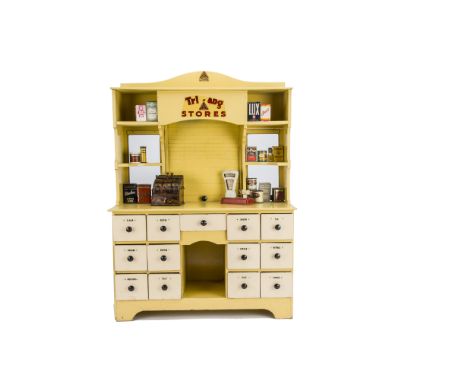 A Tri-ang Wooden No E Stores 3128, painted pale yellow with thirteen drawers with produce labels, shelf until with glazing an