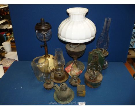 A box of vintage oil lamps including Tilley lamp and milk glass shade.
