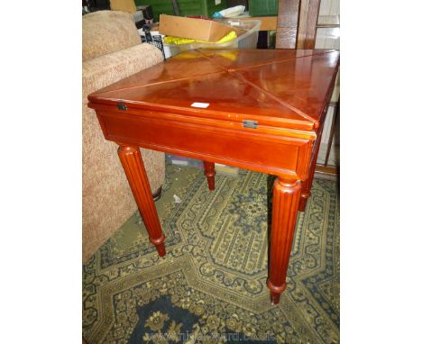 A rich Mahogany/Satinwood finish envelope Card Table having inset black surface to the top and standing on turned and reeded 