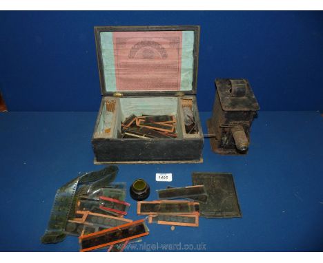 A 1920's child's tin plate slide and film projector by WW Germany together with a wooden box of glass and celluloid slides, a