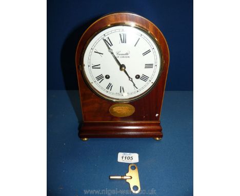 A wooden Mantle Clock by Comitti of London with shell decoration and brass bun feet, 9 1/2'' tall, with key.