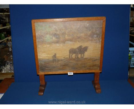 An Oak Art Deco style Firescreen framing an oil painting of horses pulling a plough, 17" x 14".