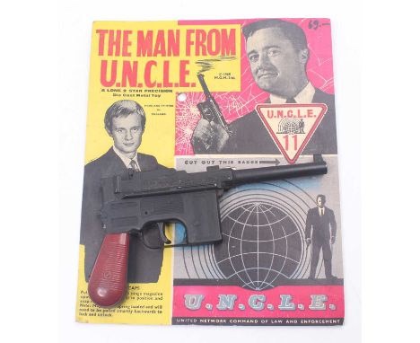 Lone Star 1965 The Man From Uncle Diecast metal Cap firing gun with maroon handle, strung to a pictorial backing card