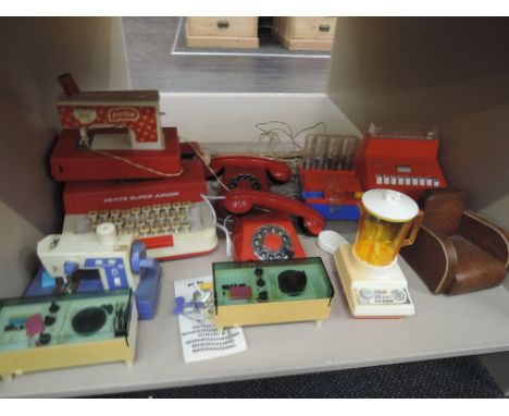 A shelf of 1970's and later plastic accessories and toys including Sindy record players, Petite typewriter and sewing machine