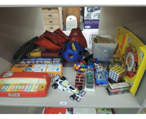 A shelf of 1970's and later mixed toys and puzzles including Rubik cubes, Burago Williams F1 car etc