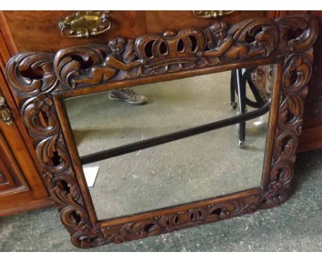 Unusual 19th century Continental mirror in elaborately carved and pierced frame with cherub and crown detail, 28" wide  