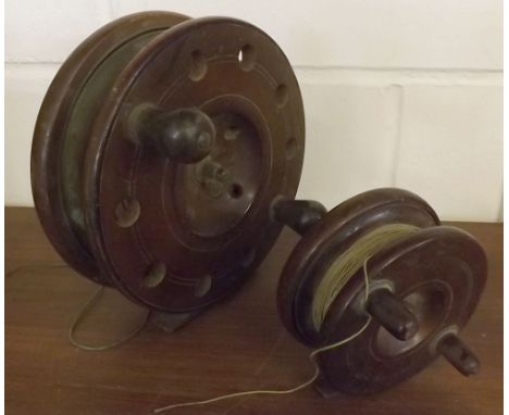 Vintage turned hardwood centre pin fishing reel, 7" diameter, unsigned, together with a further smaller example (2)  