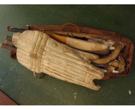 Vintage sports bag containing: vintage hockey sticks, cricket bat, cricket pads, cricket balls, gloves, sports shoes etc (qty