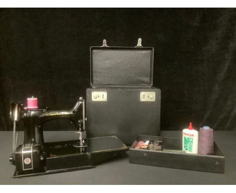 A Singer electric sewing machine, 221K, serial number EH242667, in original carry case with manual, bobbins, cottons and othe