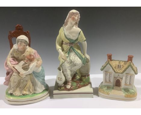 A Staffordshire pearlware figure, The Widow of Zaraphath, 23cm high, c.1800; a Staffordshire model, of a cottage; a Staffords