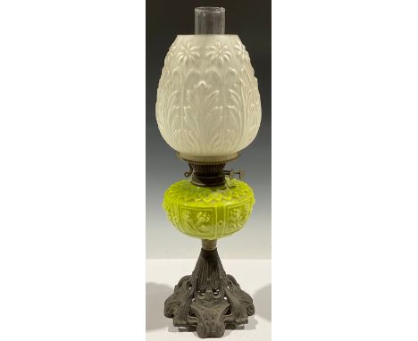 An ornate Victorian oil lamp, the glass shade decorated with daisies and acanthus, terminating with a ceramic font decorated 