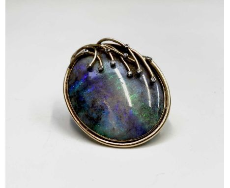 A contemporary oval opal brooch, set in 9ct gold, over the stone there lies eight naturalistic fronds each of which is diamon