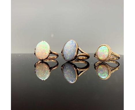 Three gold rings each set an oval opal 8.5gmCondition report: Rubbed over setting Size O 1/2 1928 Birmingham 9ct, A little sc