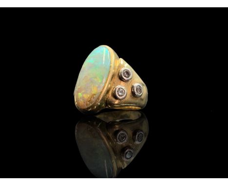 An 18ct gold ring set an opal flanked by three collet-set diamonds on each shoulder 12.6gmCondition report: Approx size M-N.