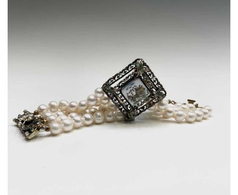 A four strand pearl bracelet with square central enamel panel depicting a country cart and horse scene.The panel surround and