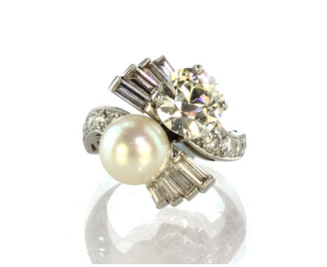 A pearl and diamond dress ring in white gold or platinum set with a large pearl measuring 9.2mm in diameter, beside a round c