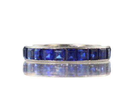 CARTIER - A sapphire eternity ring by Cartier in 18ct white gold set with twenty two princess cut blue sapphires. Ring size M