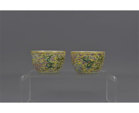 A pair of Chinese 19th century Famille-rose porcelain wine cups decorated with nine dragons. Six character mark of Yongzheng.