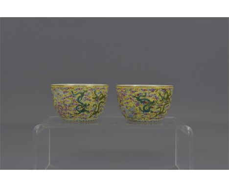 A pair of Chinese 19th century Famille-rose porcelain wine cups decorated with nine dragons. Six character mark of Yongzheng.