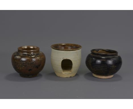 Two Chinese Song Dynasty pottery brown-glazed jars and a pottery oil lamp. 9cm tall (each)   Provenance: From an English priv