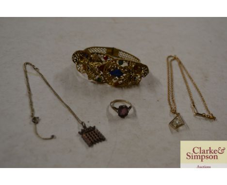 A yellow metal pendant and chain; a silver pendant and chain; a silver ring and a filigree type snap bangle 