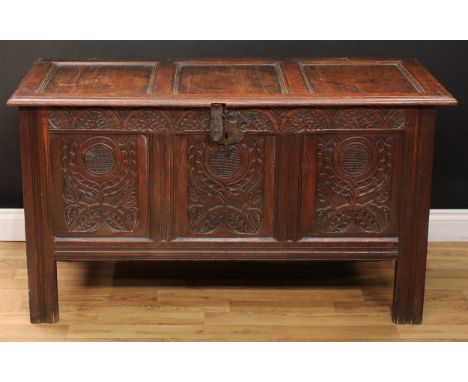 A late 17th century oak three-panel blanket chest, hinged cover, the front carved with leafy lunettes and stylised flowers, s