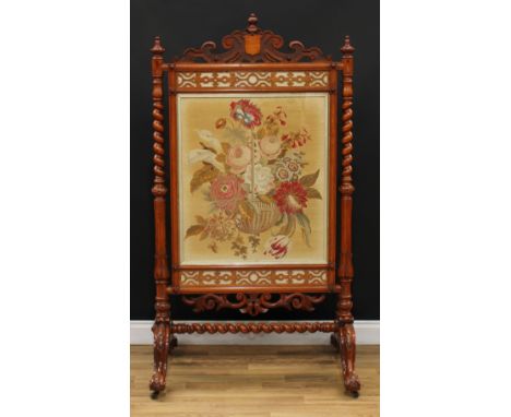 A substantial Victorian oak firescreen, shaped and pierced cresting carved with scrolls, above a rectangular banner worked wi