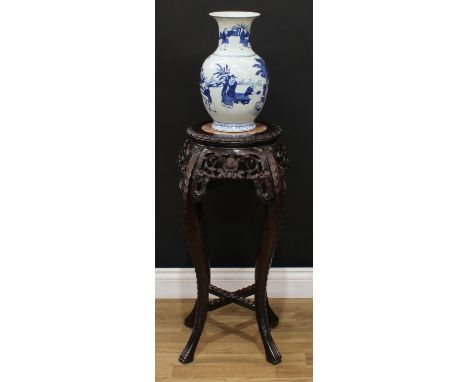 A Chinese hardwood vase or jardiniere stand, circular top with inset soapstone panel, above a deep frieze pierced and carved 